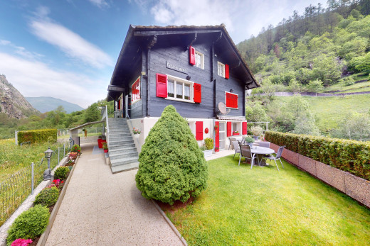 außenansicht mit waldblick, zaun, rasen, und blick auf die berge