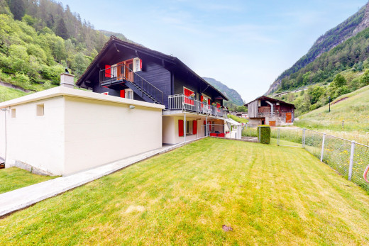 außenansicht mit balkon, blick auf die berge, zaun, und rasen