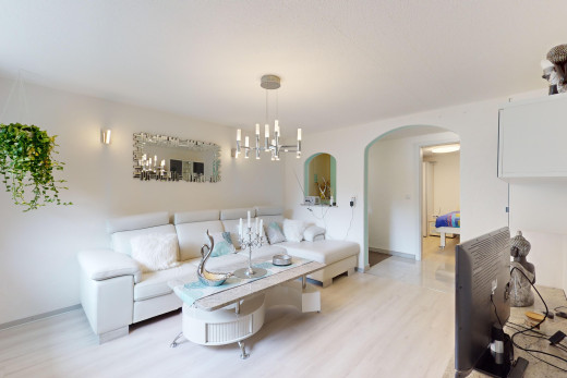 salon avec lustre, plancher de bois, et passerelles voûtées