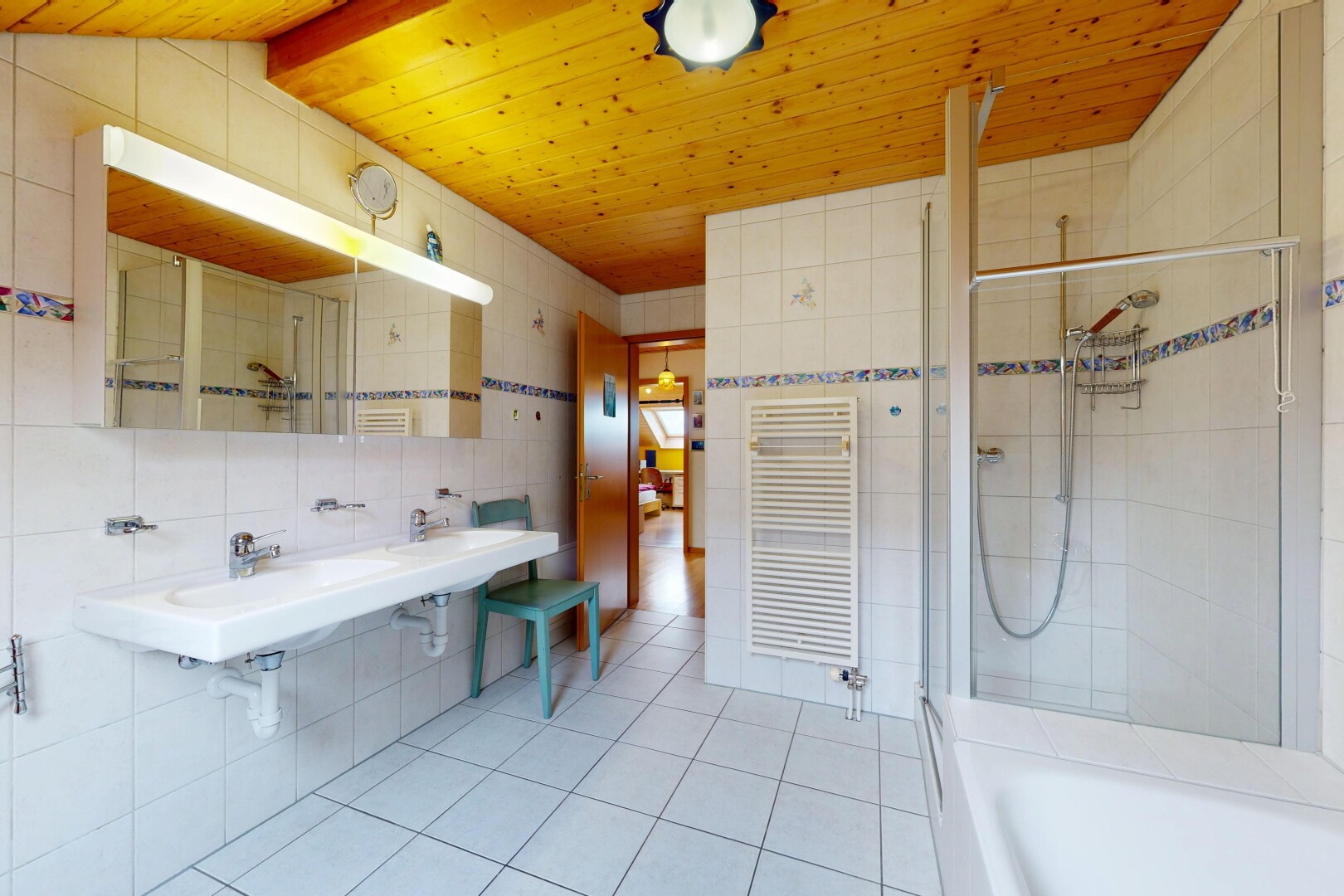 full bath featuring a stall shower, tile walls, a towel warmer, a tub, and radiator