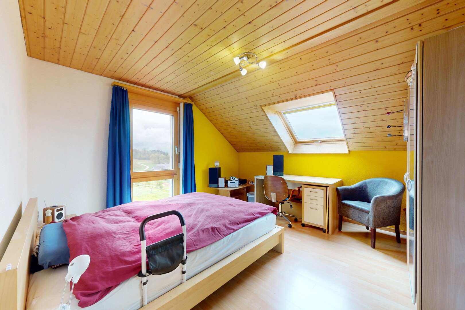 room featuring a vaulted wood ceiling, light wood-style flooring, a skylight, and a desk