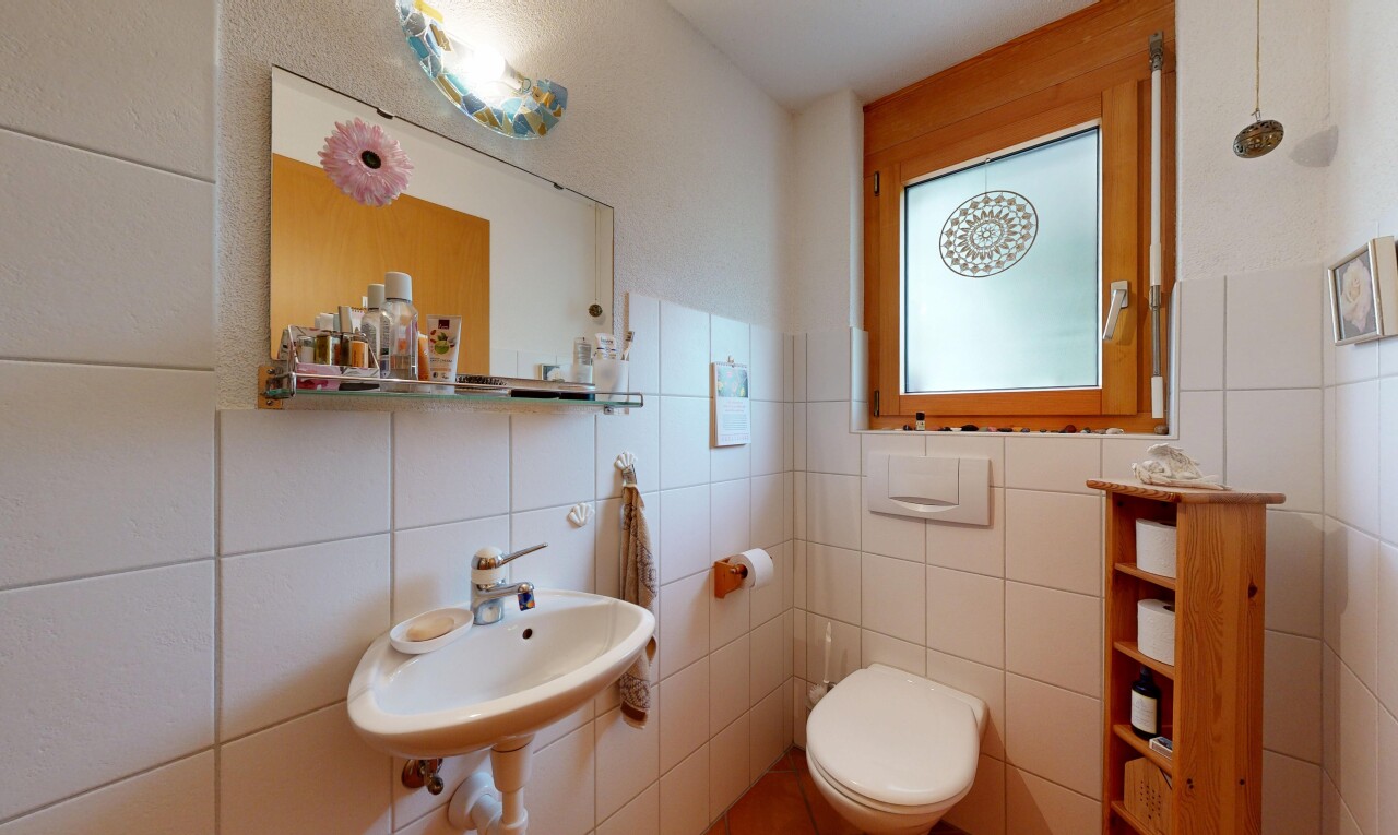 bathroom with a sink and tile walls