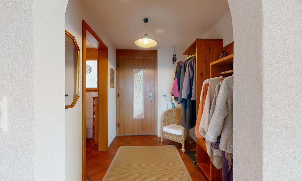 walk in closet with light tile patterned floors and arched walkways