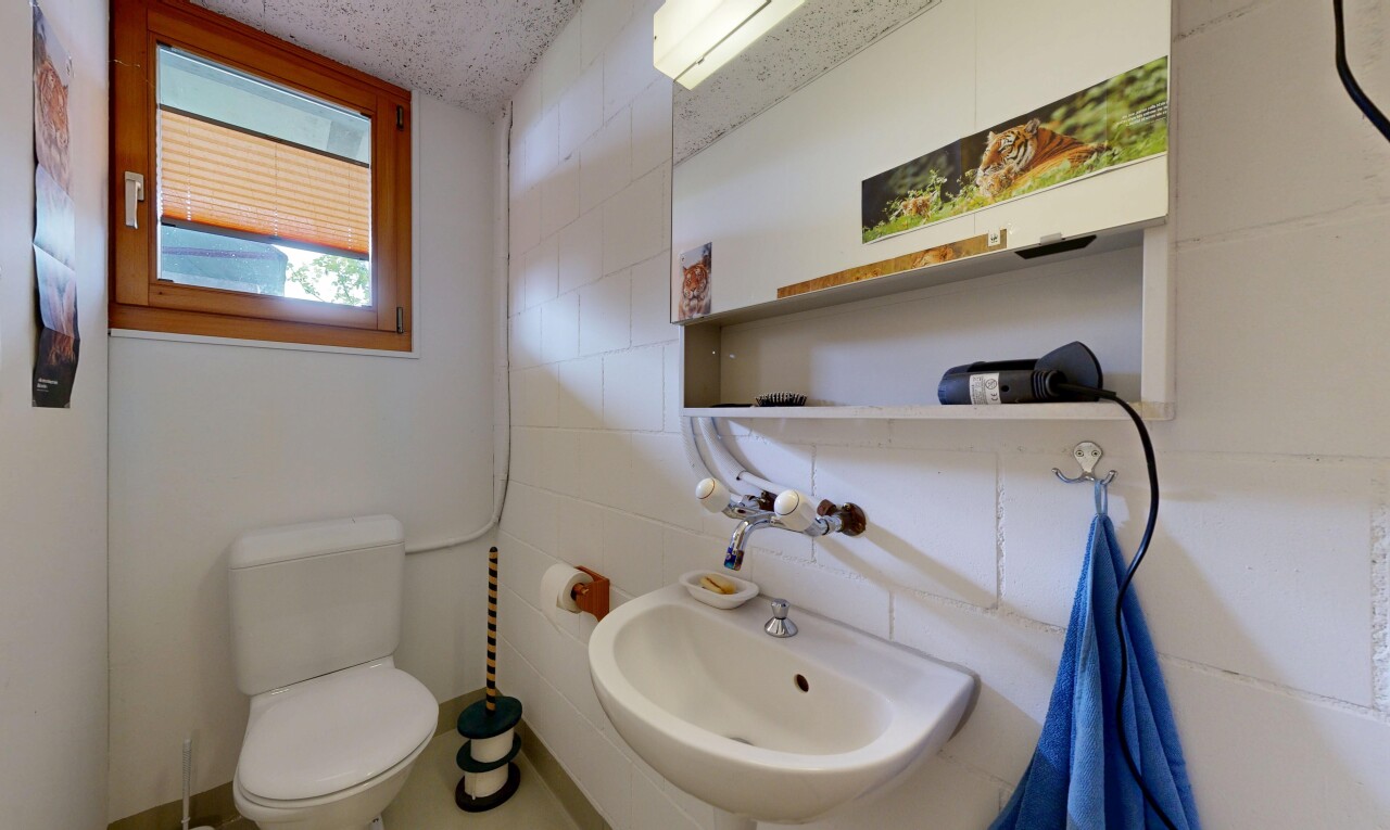 half bathroom with toilet and tile walls