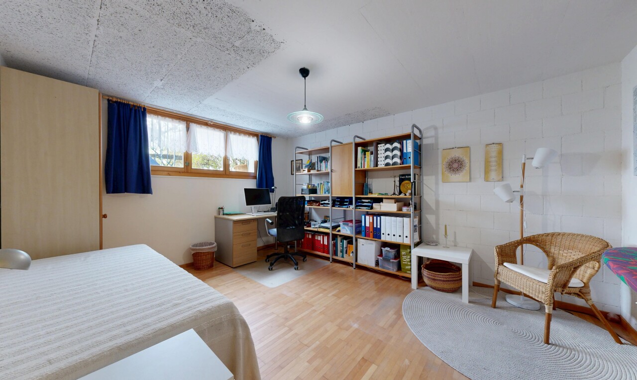 room / bedroom featuring light wood finished floors and an office area