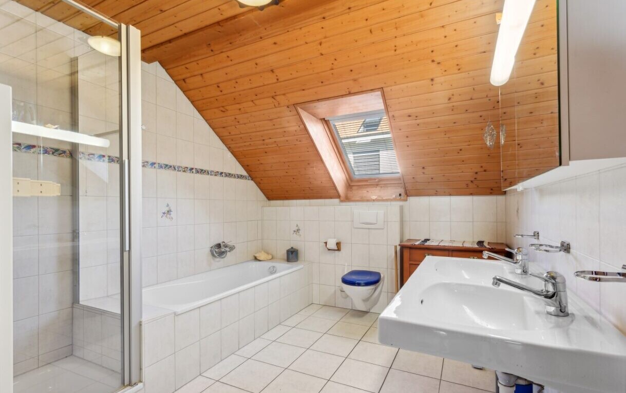 full bath featuring a garden tub, a shower stall, light tile patterned floors, tile walls, and a skylight