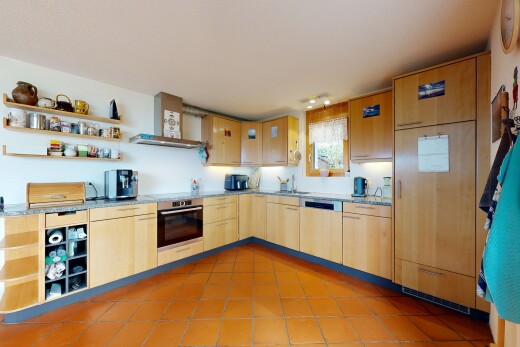 kitchen featuring open shelves, light wood finish cabinetry, stainless steel appliances, light stone counters, and light tile patterned floors