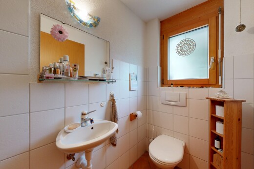 salle de bains avec miroir, évier, inside property, toilette, et tile wall