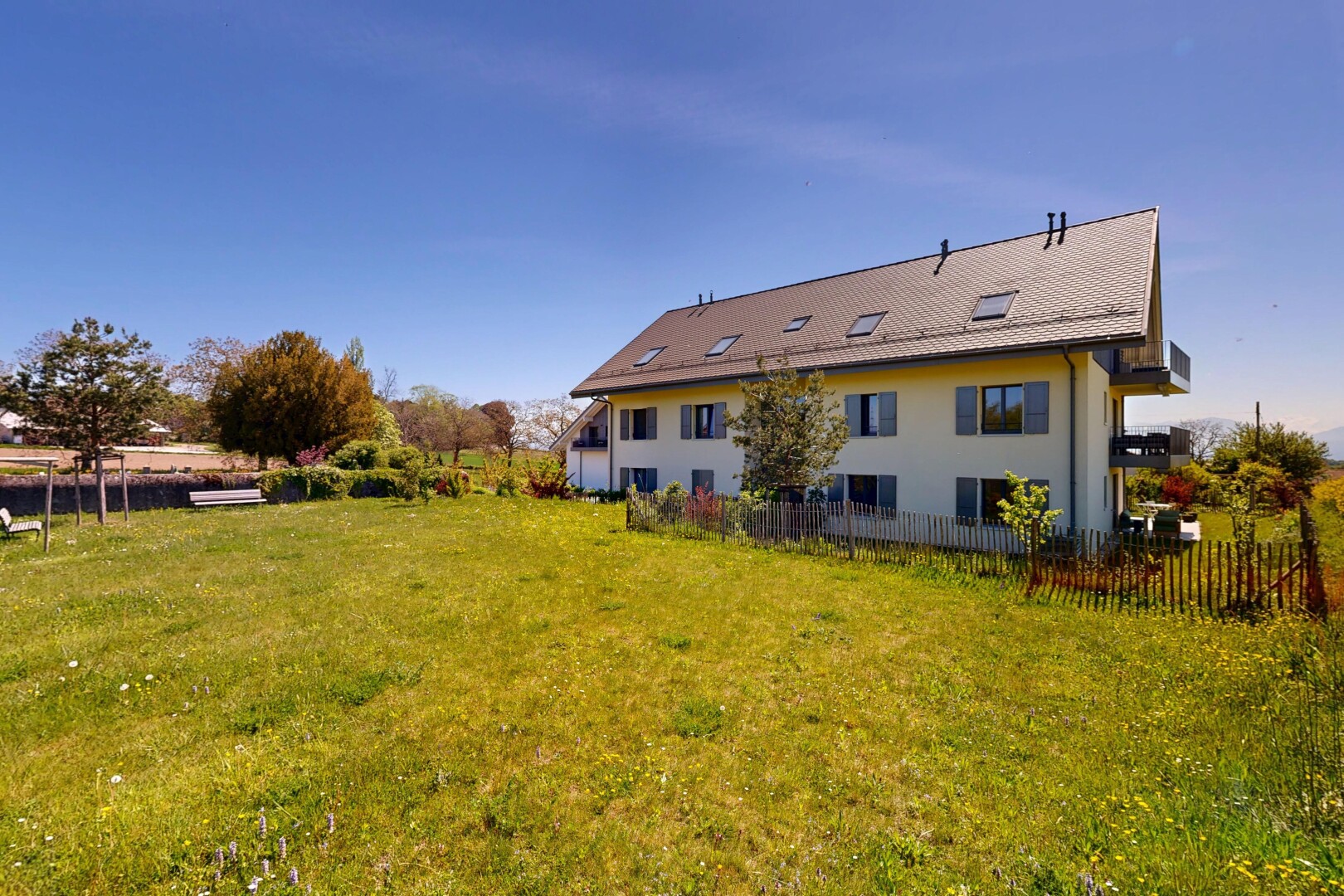 façade avec property visible, pelouse, clôture, bardage en stuc, et day time