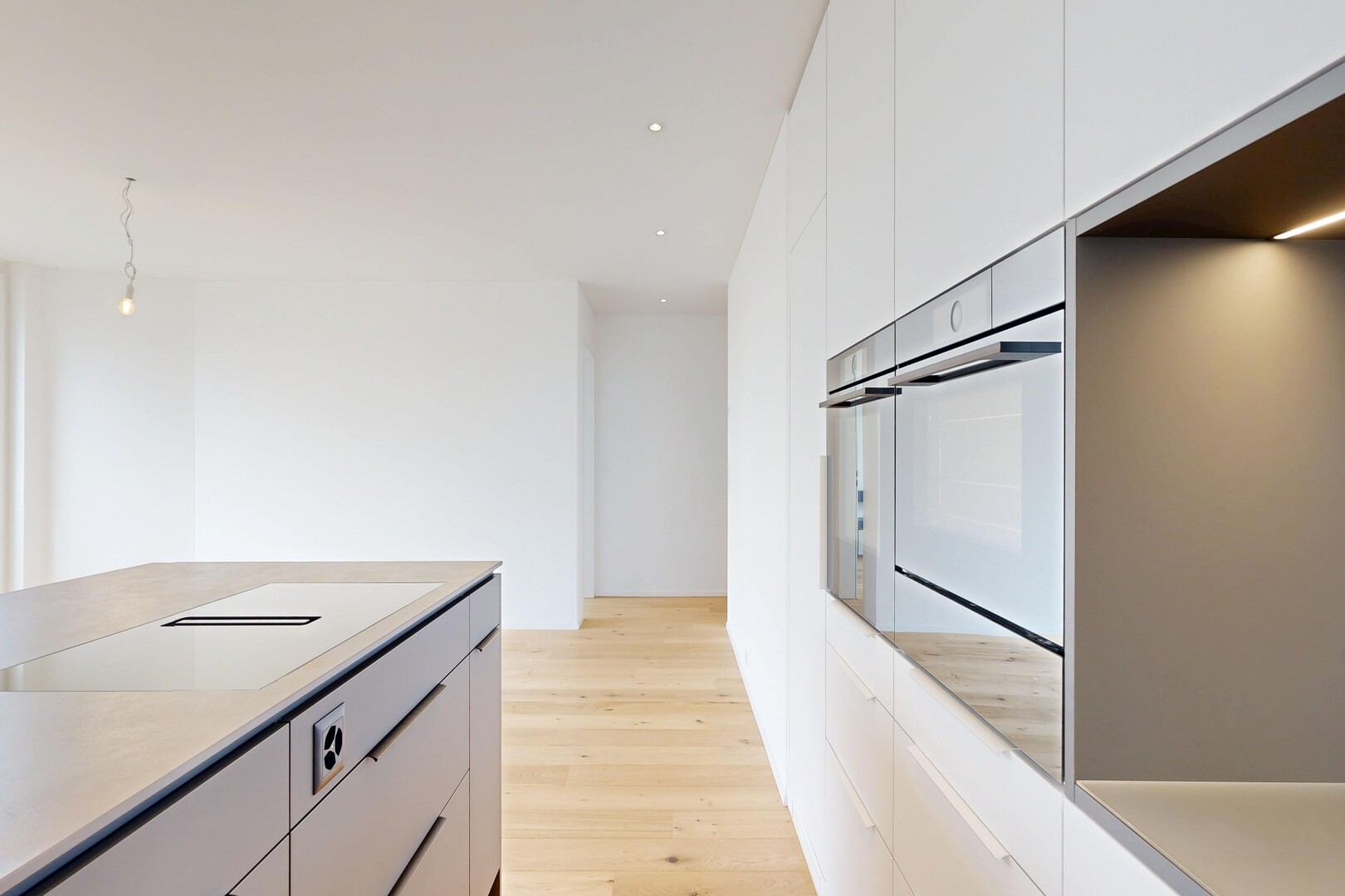 cuisine avec armoires à panneau plat, flat panel cabinets, light countertops, light floor, et sol en finition bois