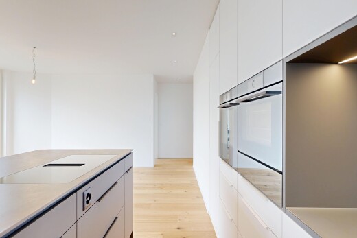 cuisine avec armoires à panneau plat, flat panel cabinets, light countertops, light floor, et sol en finition bois