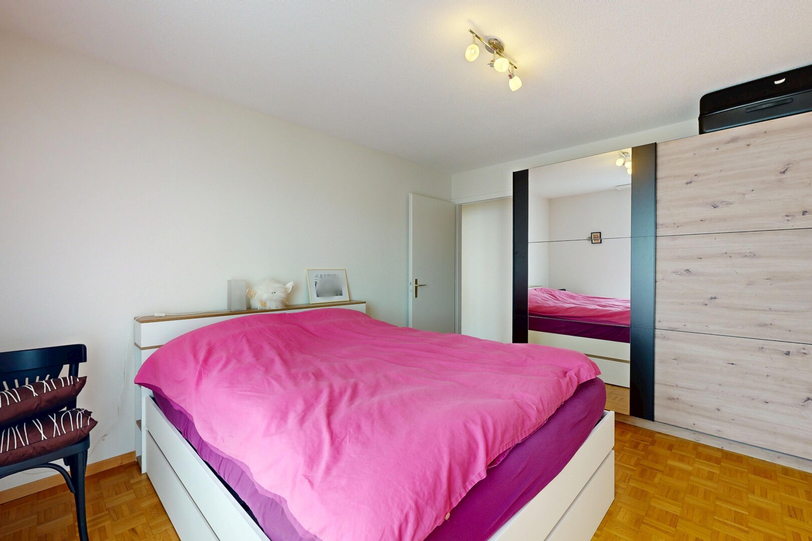 chambre avec parquet floor, sol en finition bois, wood finish floor, inside property, et light floor