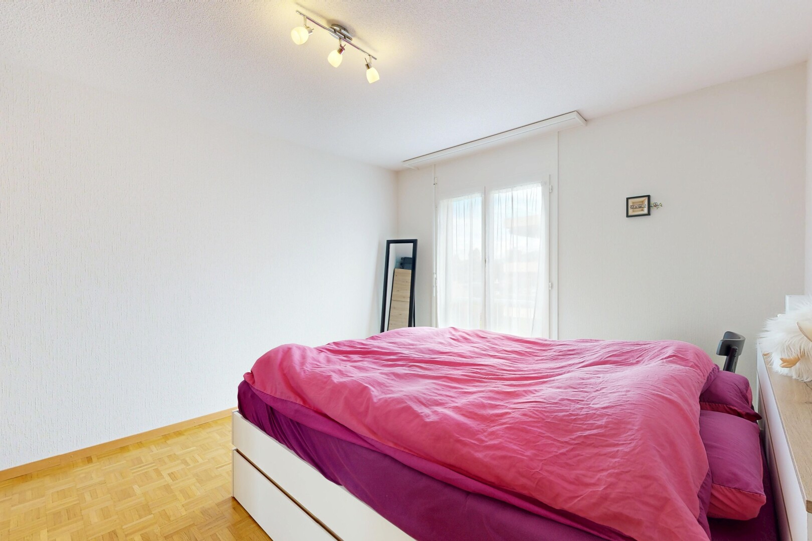 chambre avec sol en finition bois, wood finish floor, parquet floor, inside property, et lumière naturelle