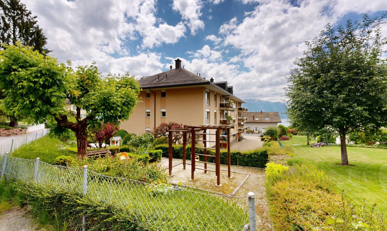 façade avec pergola, pelouse, bardage en stuc, day time, et property visible