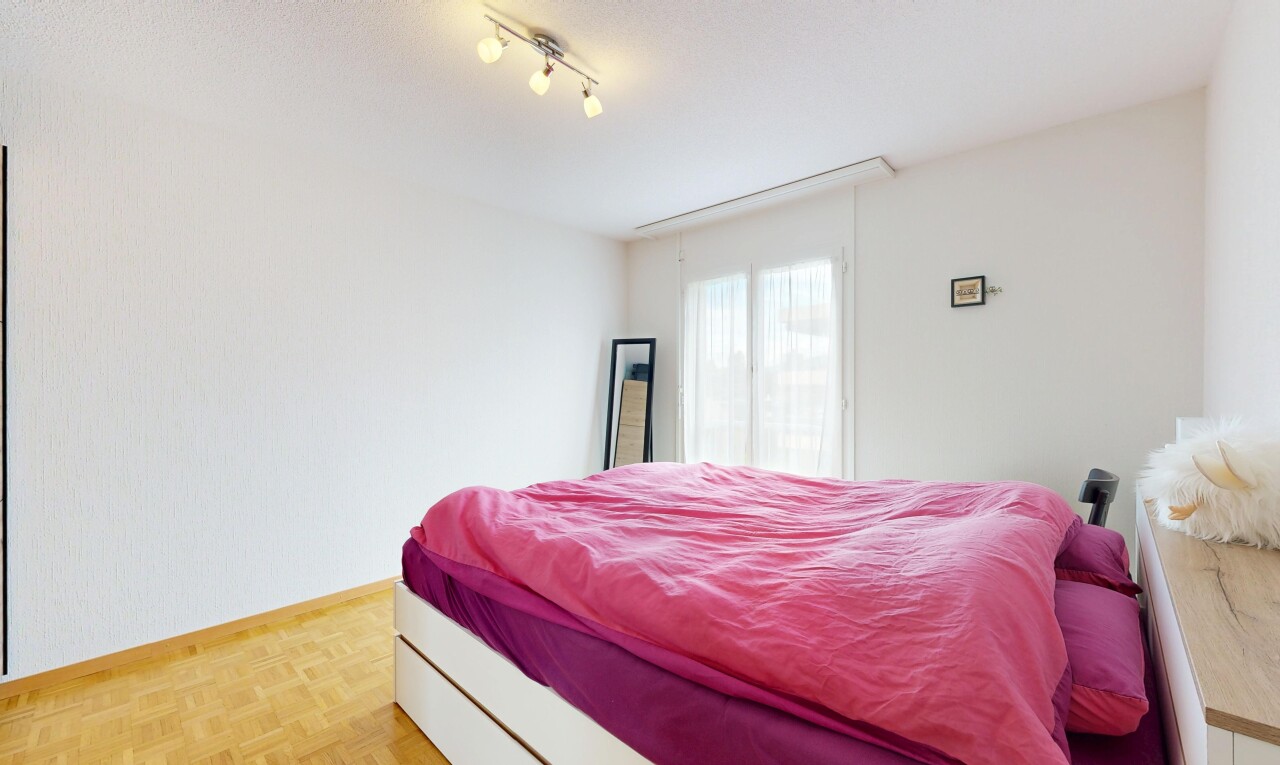 chambre avec sol en finition bois, wood finish floor, parquet floor, inside property, et lumière naturelle