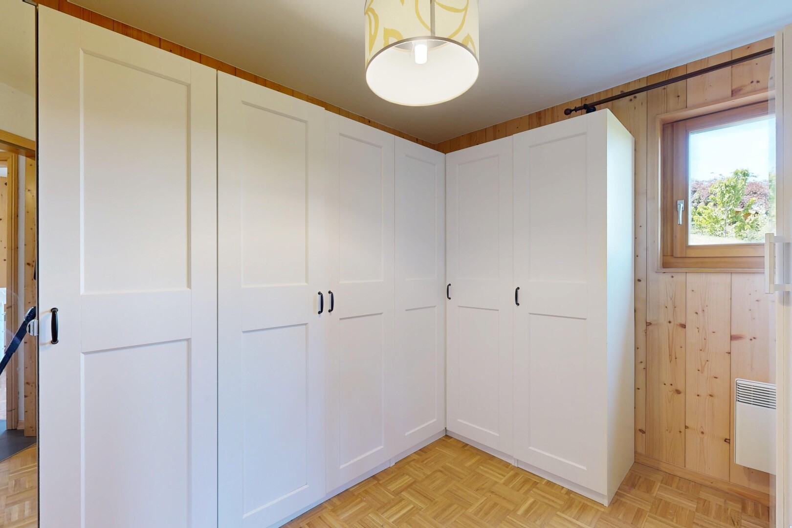 chambre avec parquet floor, sol en finition bois, wood finish floor, inside property, et lumière naturelle