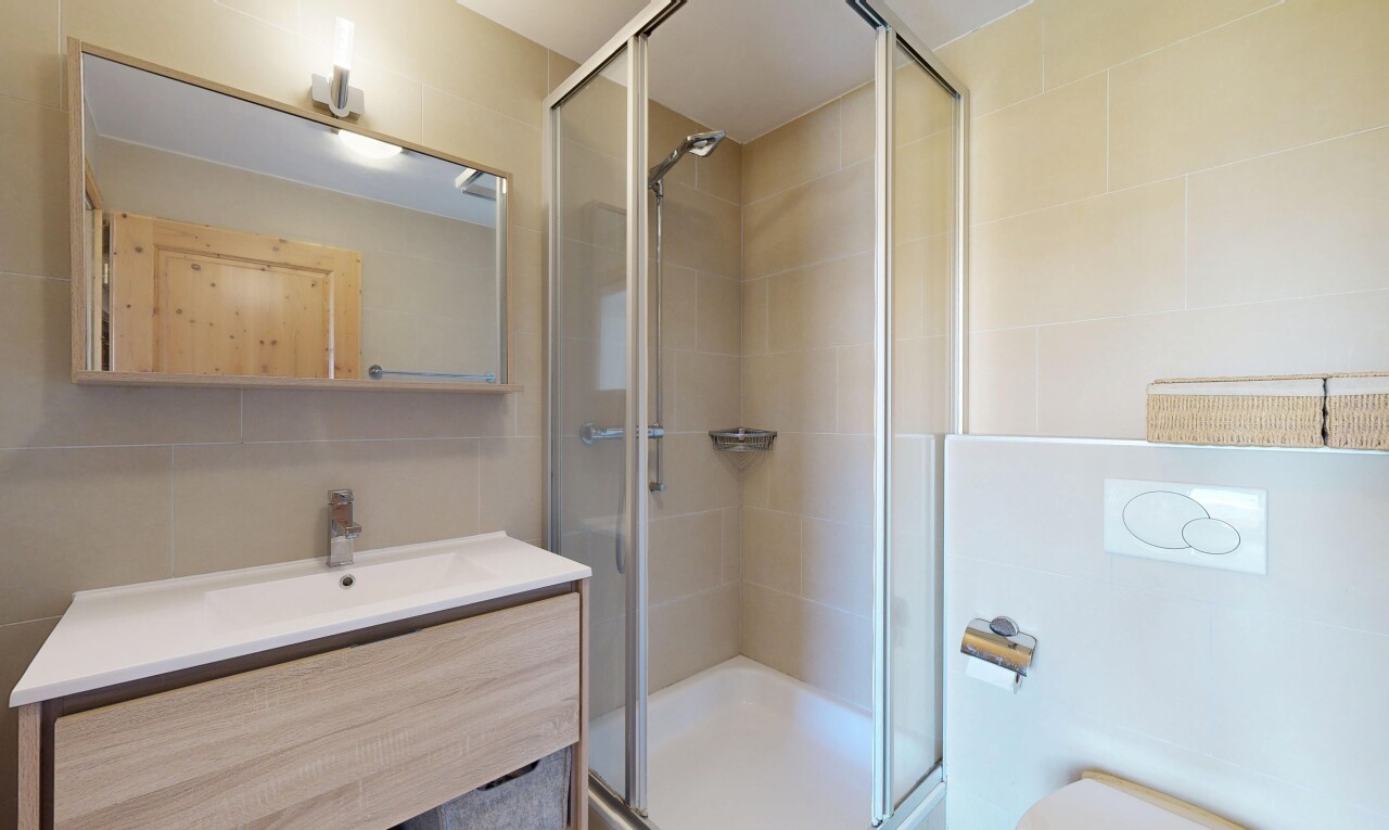 salle de bains avec lavabo (ou coiffeuse selon le contexte), salle de bain complète, douche, mur en carrelage, et tile wall