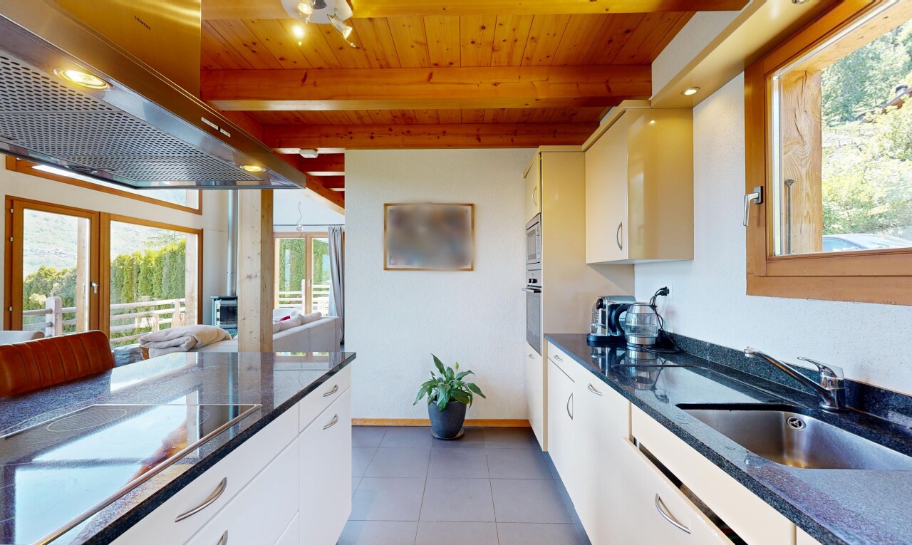 cuisine avec dark countertops, hotte, lumière naturelle, natural light, et armoires blanches