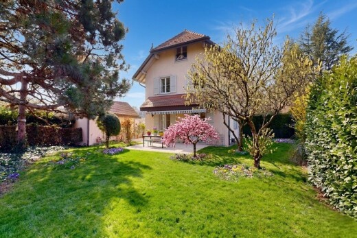 façade avec property visible, terrasse, bardage en stuc, pelouse, et day time