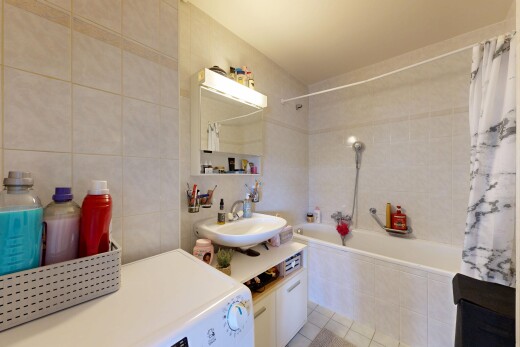 salle de bains avec tile wall, mur en carrelage, lave-linge et sèche-linge, inside property, et lavabo (ou coiffeuse selon le contexte)