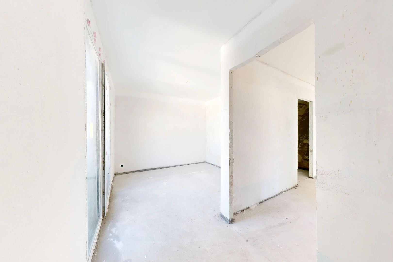 pièce vide avec inside property, concrete floor, sol en béton, drywall, et cloison sèche