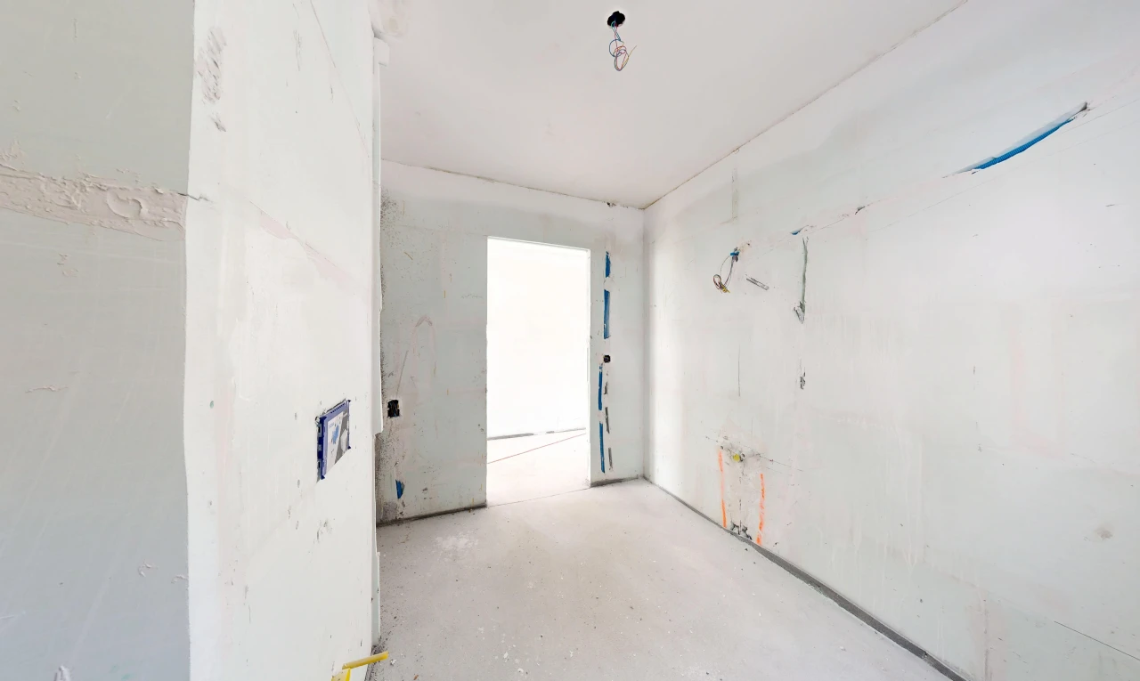 pièce vide avec inside property, concrete floor, sol en béton, drywall, et cloison sèche