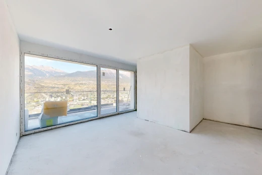 pièce vide avec vue sur la montagne, mountain view, accès à l'extérieur, concrete floor, et sol en béton
