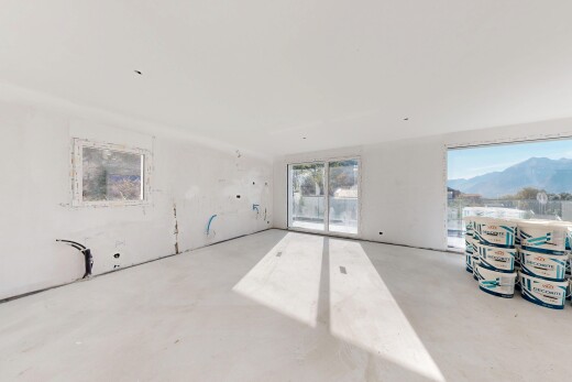 pièce vide avec inside property, accès à l'extérieur, sol en béton, concrete floor, et mountain view