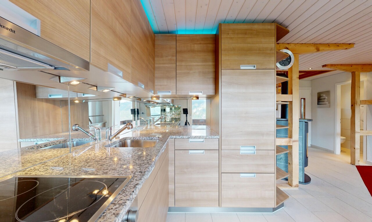 cuisine avec armoires marron clair, light brown cabinets, plaque de cuisson, plans de travail en pierre, et stone countertops