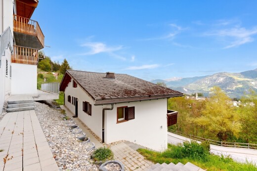 outdoor house with stucco siding, a mountain view, and a balcony