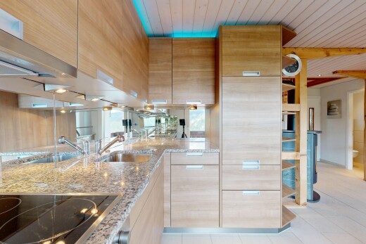 cuisine avec armoires marron clair, light brown cabinets, plaque de cuisson, plans de travail en pierre, et stone countertops