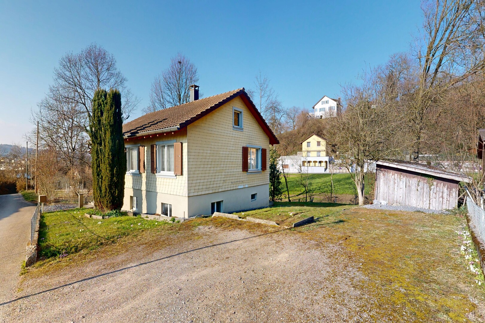 façade avec bardage en bardeaux, day time, property visible, fondation en béton, et pelouse