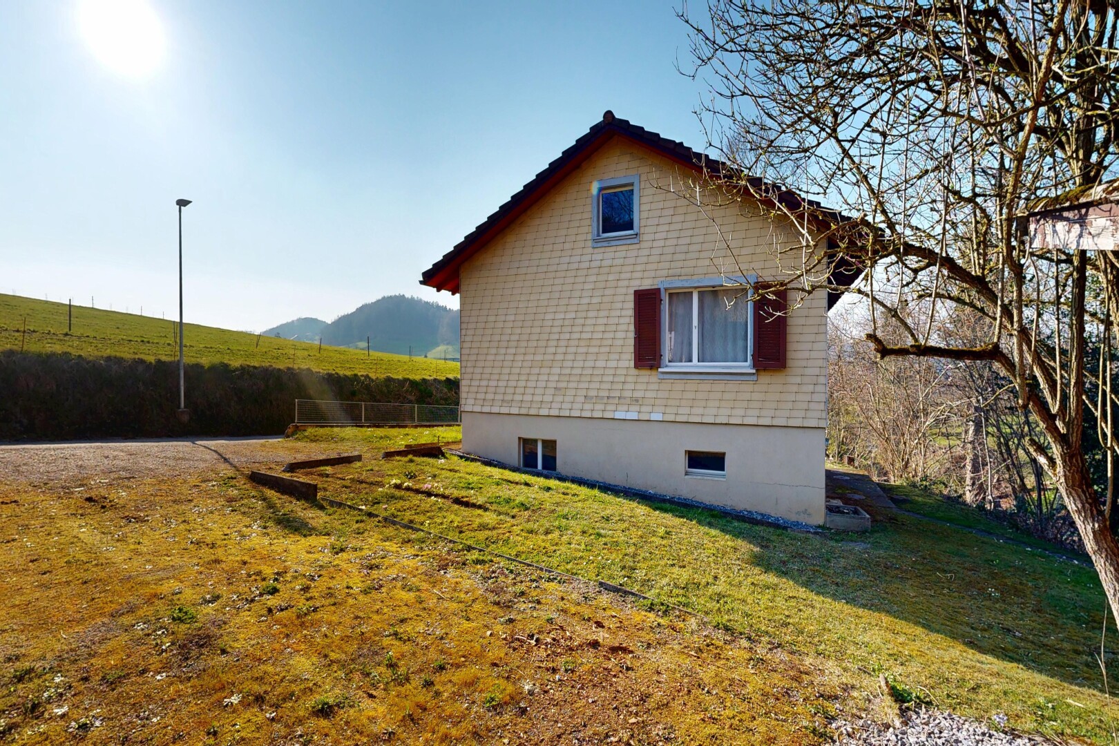 façade avec fondation en béton, bardage en bardeaux, pelouse, from property, et day time