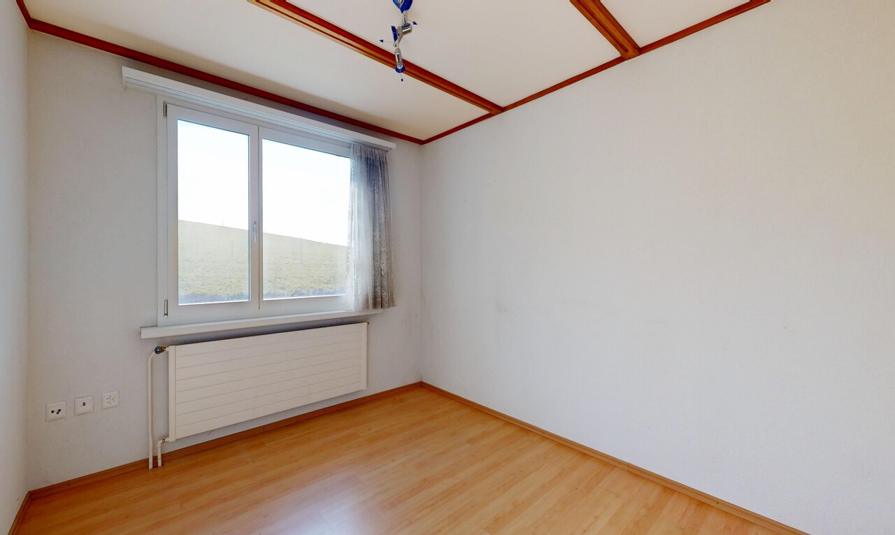 pièce vide avec radiateur, sol en finition bois, wood finish floor, lumière naturelle, et natural light
