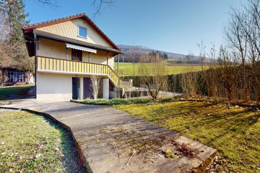 view of home featuring a yard and a balcony