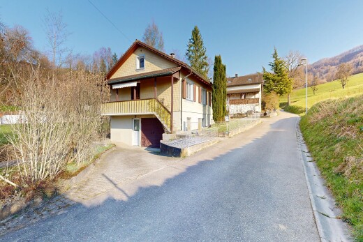 outdoor house featuring a garage, a balcony, and driveway