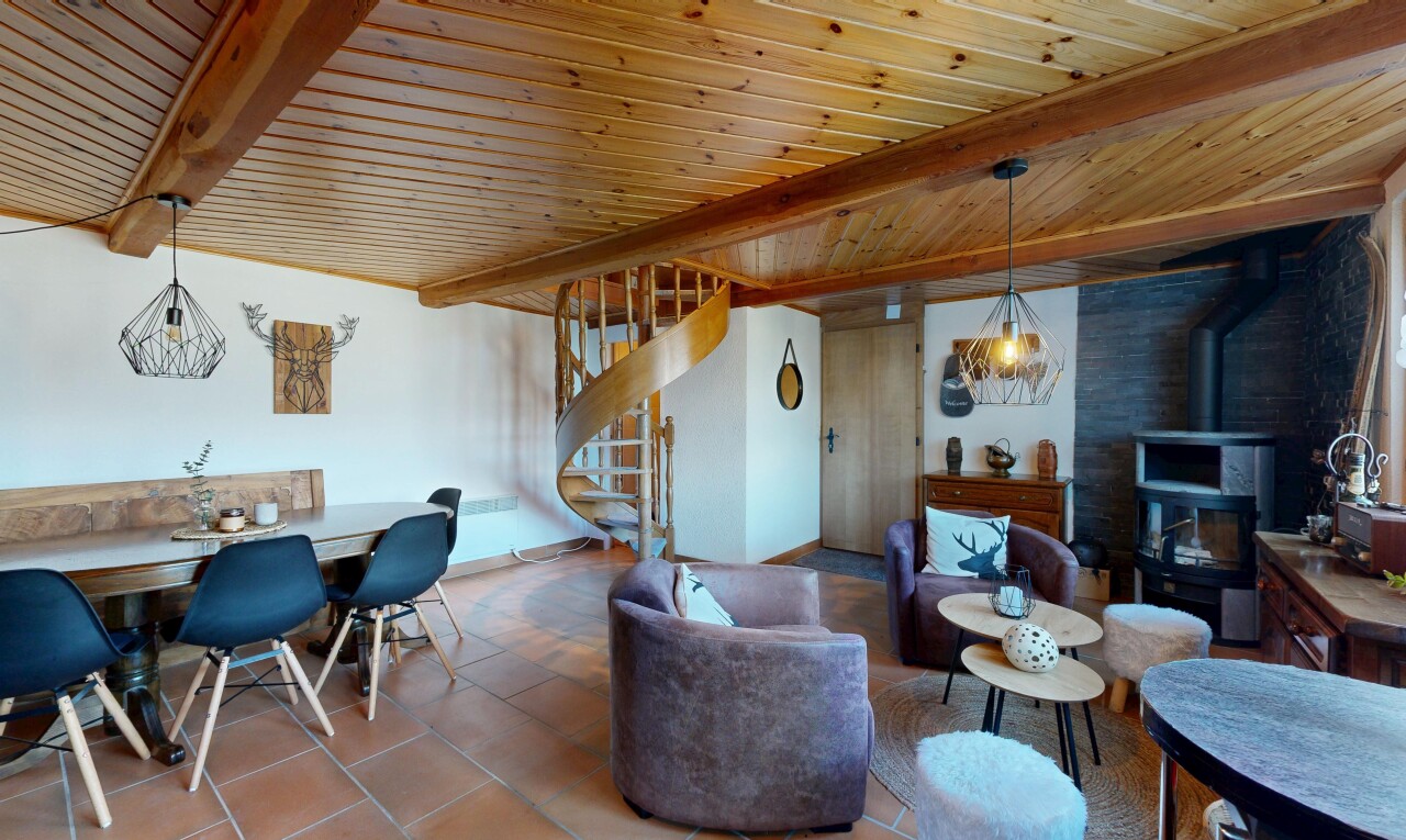 wohn- / esszimmer mit holzofen, beamed ceiling, balkendecke, inside property, und treppen