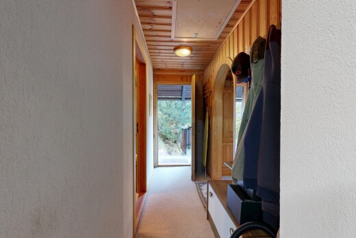 hallway with attic access and light colored carpet
