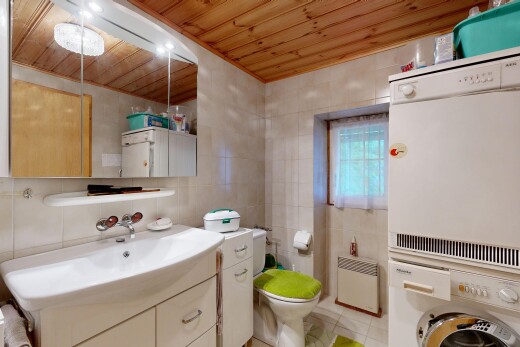 salle de bains avec mur en carrelage, tile wall, lave-linge et sèche-linge, miroir, et inside property