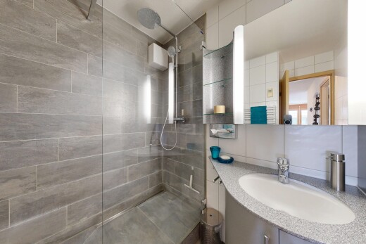 bad mit spiegel, schminktisch, waschbecken, inside property, und dusche
