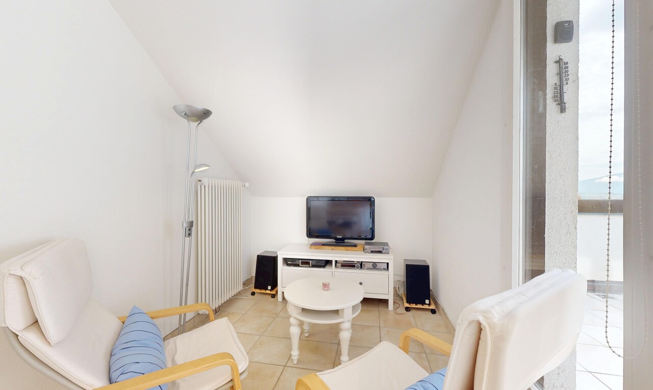 salon avec télévision, radiateur, drywall, cloison sèche, et tile floor