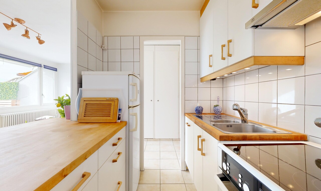 cuisine avec armoires blanches, inside property, hotte, backsplash, et dosseret