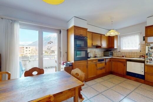 küche mit geschirrspülmaschine, mittelbraune schränke, doppel backofen, natürliches licht, und küchenrückwand beim herd