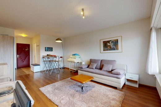 salon avec cloison sèche, drywall, inside property, sol en finition bois, et wood finish floor