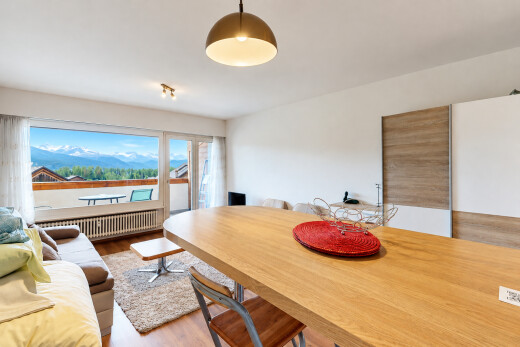 salon / salle à manger avec accès à l'extérieur, radiateur, drywall, cloison sèche, et wood finish floor