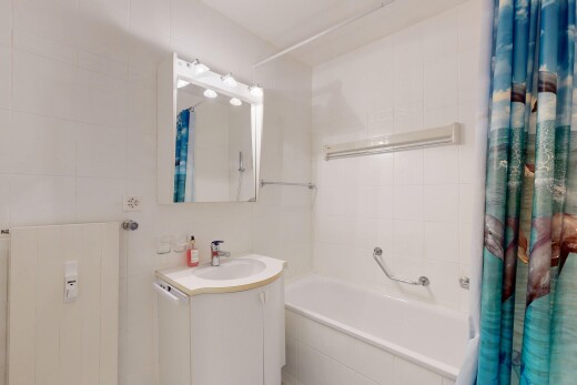 full bath with tiled shower / bath, vanity, and tile walls