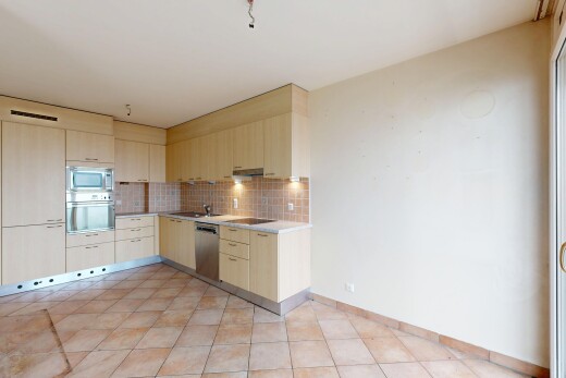 cuisine avec armoires marron clair, plans de travail, dosseret, backsplash, et cloison sèche