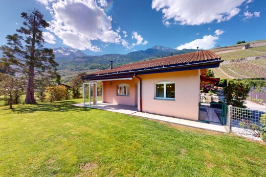 außenansicht mit rasen, blick auf die berge, stuckverkleidung, terrasse, und zaun