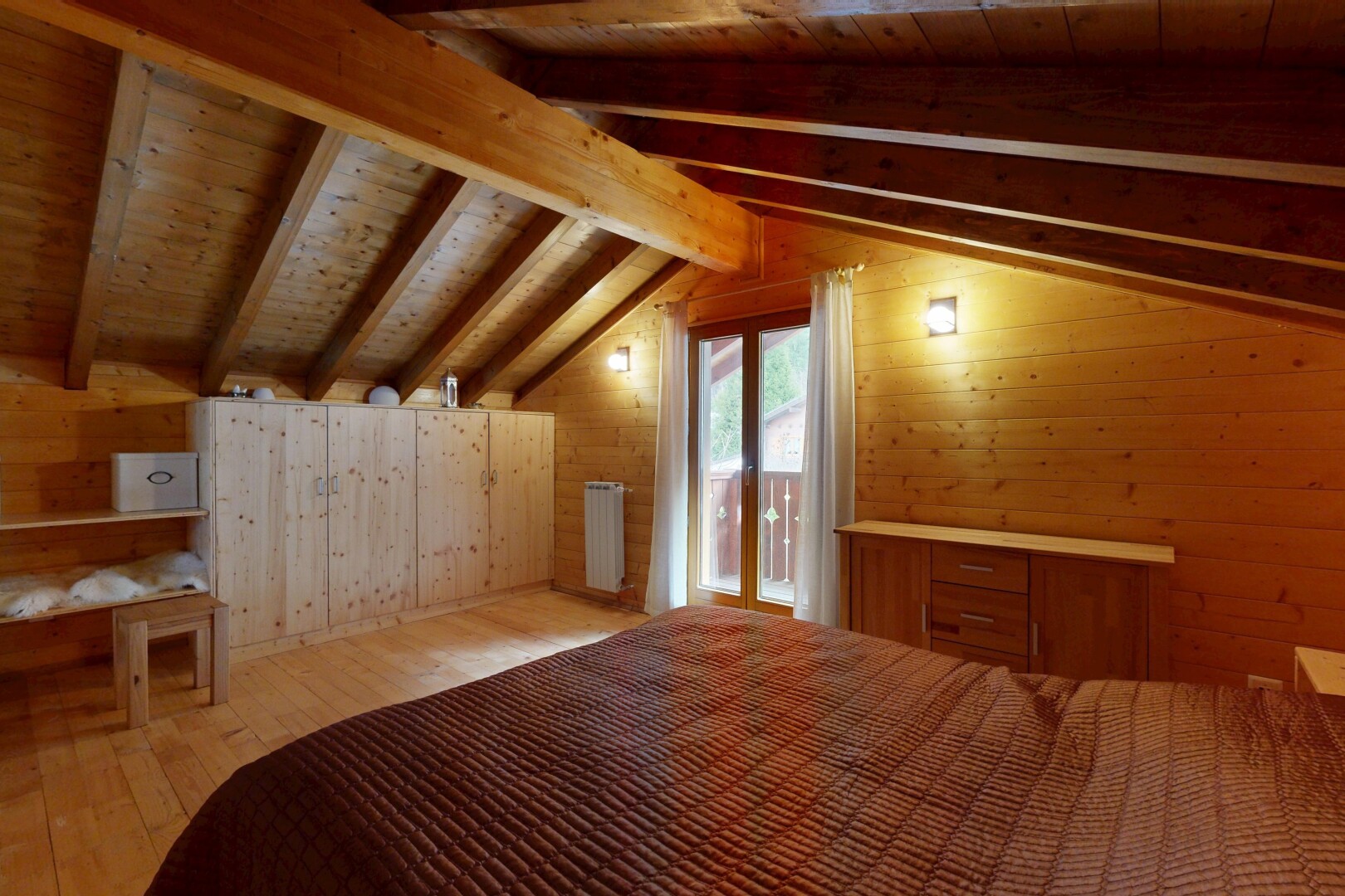zimmer / schlafzimmer mit holzwand, wood wall, kühler, balkendecke, und beamed ceiling