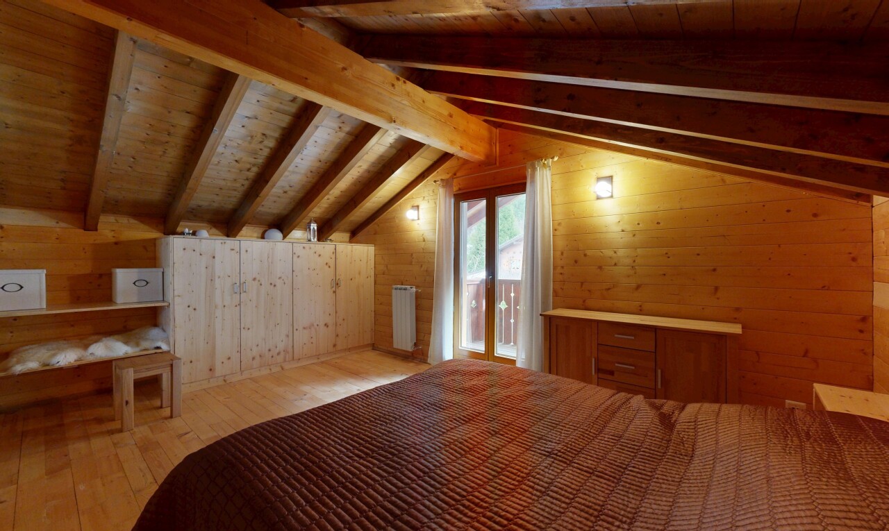 zimmer / schlafzimmer mit holzwand, wood wall, kühler, balkendecke, und beamed ceiling